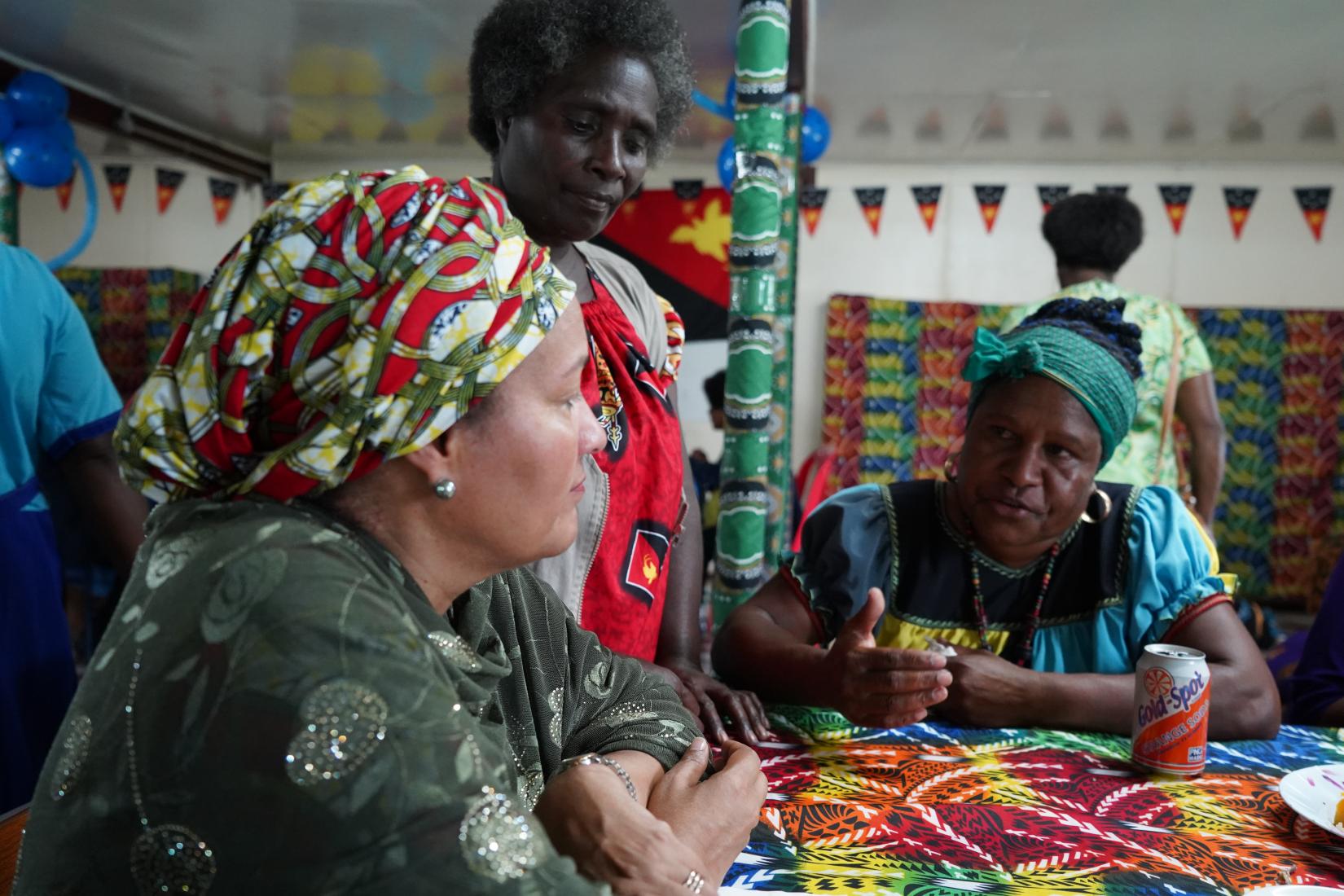 Amina Mohammed sites with local Hela woman.