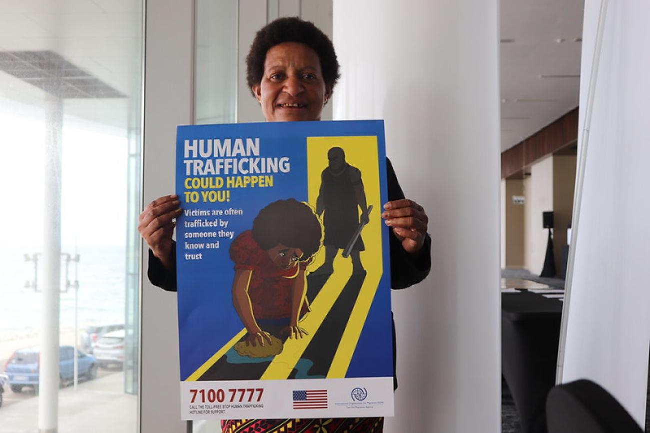 Woman holds poster on human trafficking