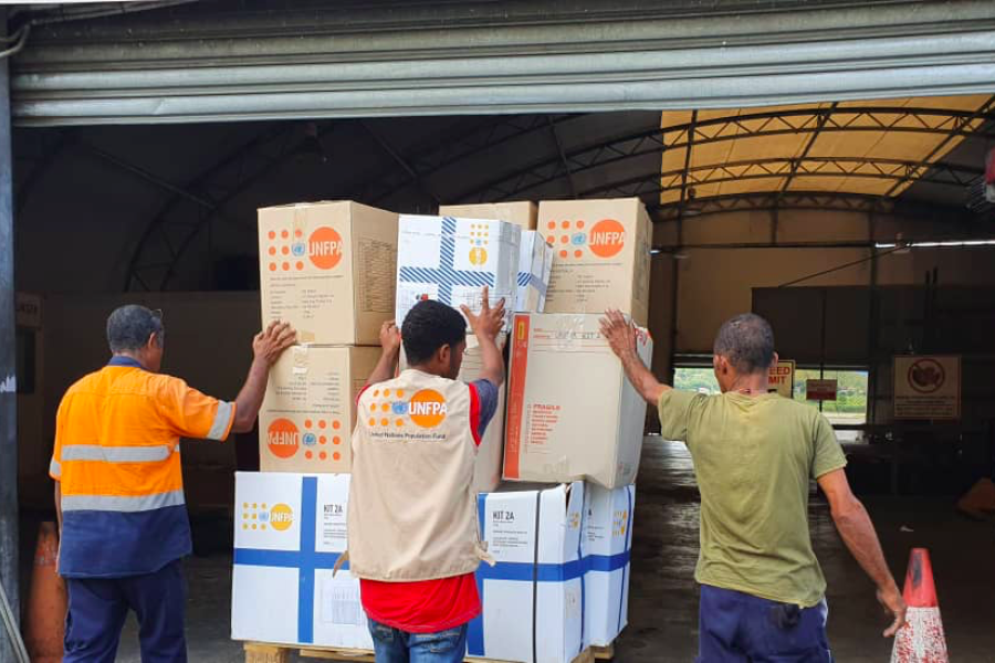 Men load UNFPA boxes into holding facility.